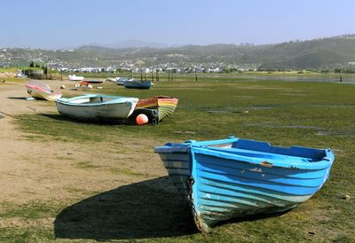 Boat moored on shore against sky