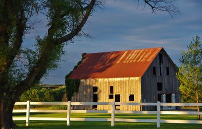 Barn on field against sky