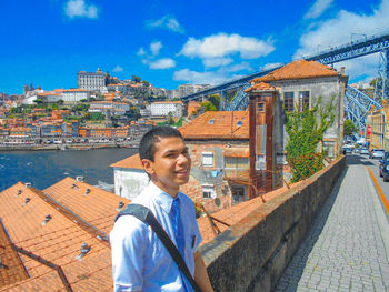 Portrait of young man standing against building