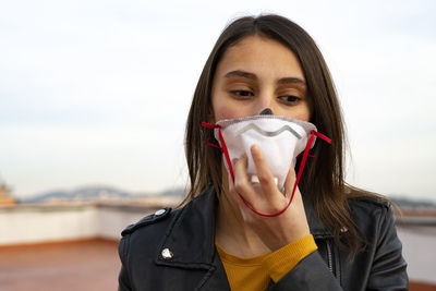 Woman putting on a doctor mask.