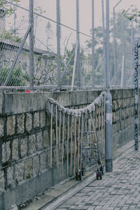 Metal fence by wall in city