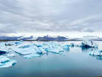 Scenic view of sea against sky with iceberg 