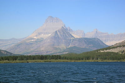 Scenic view of lake and mountains against clear blue sky