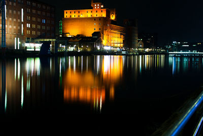 Reflection of illuminated buildings in lake at night