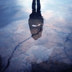 Reflection of people in puddle