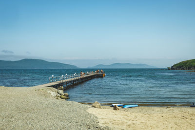Long pier in clear blue sea on sandy beach. summer vacation by sea