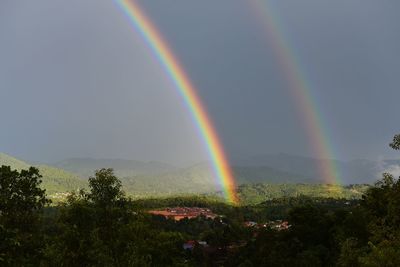 Scenic view of rainbow over mountain against sky