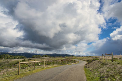 Road by landscape against sky