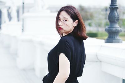 Portrait of young woman standing outdoors