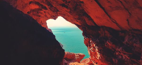 Scenic view of sea seen through cave