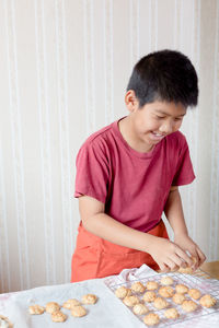 Boy placing food on cooling rack at table