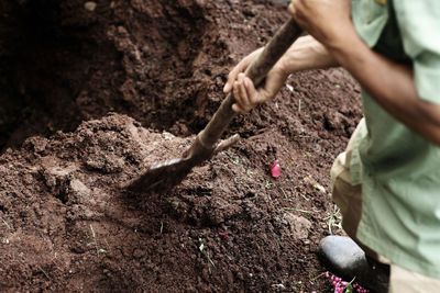 Low section of man digging mud