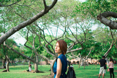 Woman standing against trees at park