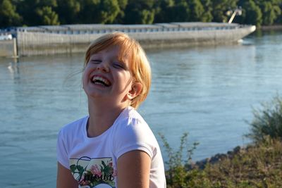 Portrait of girl laughing at riverbank