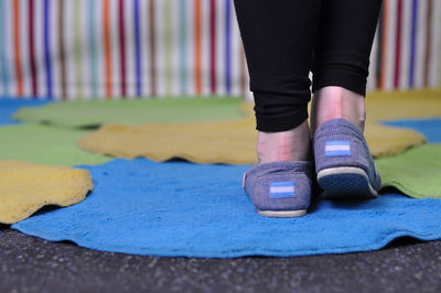 Low section of woman standing on doormat