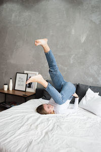 Funny lauhging woman does somersault in bed. stress free at home.