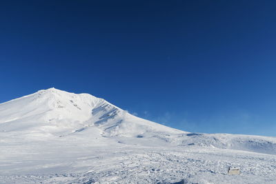 Scenic view of snowcapped mountains against clear blue sky