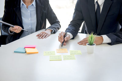 Midsection of business people working on table