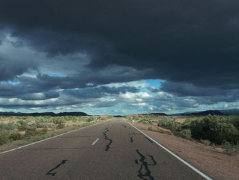 Empty road against cloudy sky