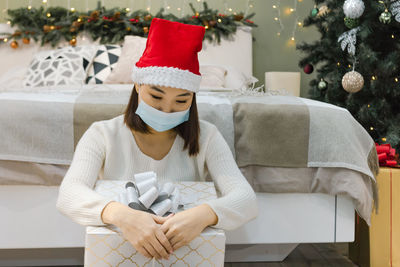 Midsection of man wearing hat on christmas tree