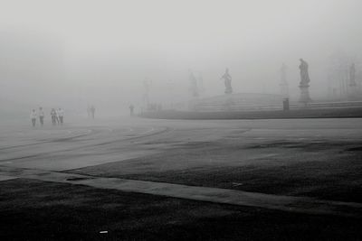 Sculptures in park during foggy weather