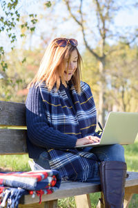 Young woman using mobile phone in park