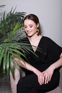 Portrait of young woman standing against white background