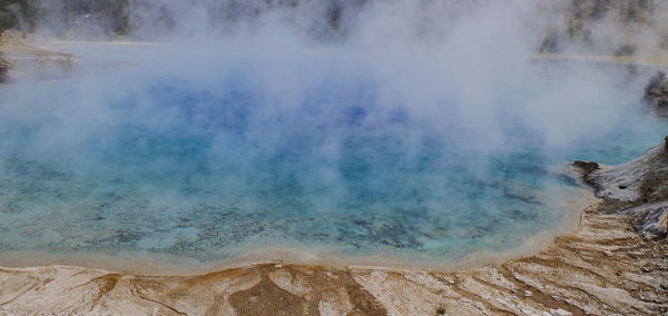 Scenic view of steam emitting from hot spring at national park