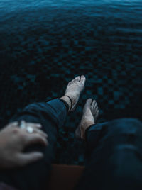 Low section of man sitting at swimming pool