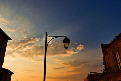 Low angle view of street lights against sky during sunset