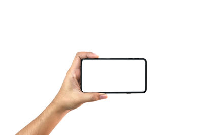 Close-up of hand holding smart phone against white background