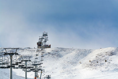 The gadein chair lift in sillian in winter, snowy ski run on the foreground, against blue sky 