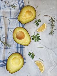 Fresh avocado with herbs and lemons lies on the table on white background. flat lay. top view.