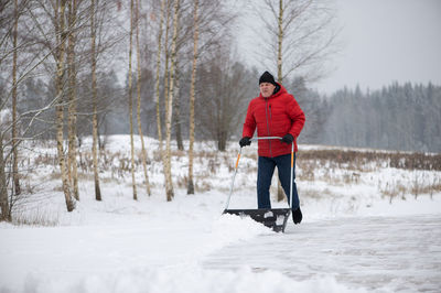 Full length of man walking on snow covered landscape