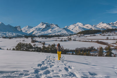 An unrecognizable young caucasian woman running towards the french alps mountains