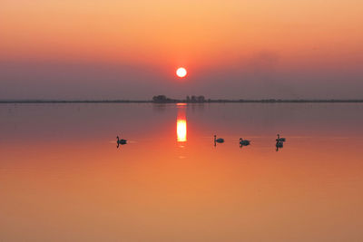 Scenic view of lake against orange sky