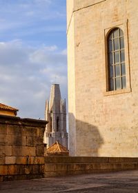 Wall of building with bell tower in background