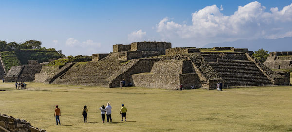 People at historical building against sky