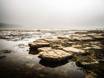 Rocks on beach against sky