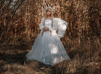 Portrait of young woman wearing costume standing against plants