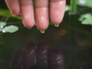 Close-up of hand with reflection in water