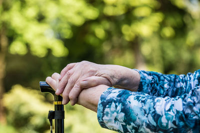 Cropped hands of senior woman holding walking