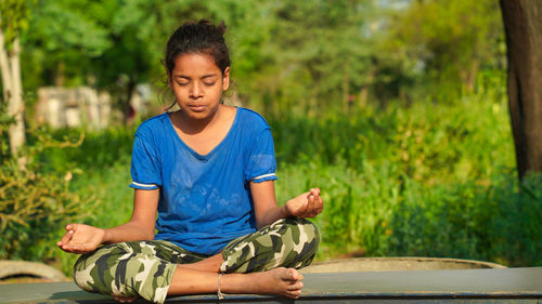 Indian child doing exercise on platform outdoors. healthy lifestyle. yoga girl.