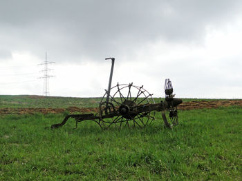 Horse cart on field against sky