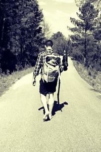 Rear view of man walking on dirt road