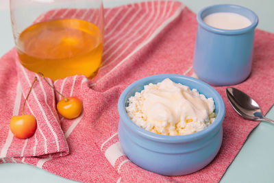 Cottage cheese in a blue bowl with sour cream and honey.