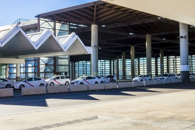 View of built structures with a line of taxi cabs at a taxi rank.