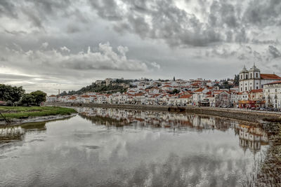 River amidst buildings in town against sky