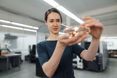 Female design professional checking three dimensional drone in workshop