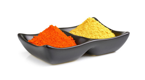 Close-up of orange slices in bowl against white background